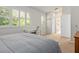 Serene bedroom with white walls, plantation shutters, and a doorway leading to a bathroom at 6215 Aventura Dr, Sarasota, FL 34241