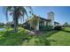 Side view of the home showcasing the screened in lanai, landscaped yard, and partial lake view at 7347 Royal Birkdale Dr, Sarasota, FL 34238