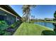 Waterfront backyard featuring well-manicured lawn and serene pond views from the home's exterior at 7347 Royal Birkdale Dr, Sarasota, FL 34238