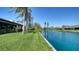 Beautiful backyard view of the lake surrounded by palm trees and lush green grass at 7347 Royal Birkdale Dr, Sarasota, FL 34238