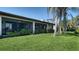 Charming backyard with a screened-in patio, green grass, and shade from mature trees at 7347 Royal Birkdale Dr, Sarasota, FL 34238
