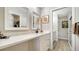 Well-lit bathroom with a long white marble countertop, double mirrors, and a view into a secondary bathroom at 7347 Royal Birkdale Dr, Sarasota, FL 34238