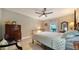 Comfortable bedroom features wood floors and a ceiling fan, with a dresser and warm furnishings at 7347 Royal Birkdale Dr, Sarasota, FL 34238