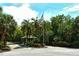 Gated entrance featuring an American flag and lush tropical landscape at 7347 Royal Birkdale Dr, Sarasota, FL 34238