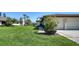 Residential home featuring manicured landscaping, green lawn, and a paved driveway to a garage at 7347 Royal Birkdale Dr, Sarasota, FL 34238