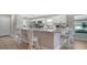 Bright kitchen featuring white cabinetry, stainless steel appliances, and a spacious marble countertop island with bar stool seating at 7347 Royal Birkdale Dr, Sarasota, FL 34238