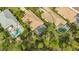 Aerial view highlighting the home's backyard pool, screened patio, and tropical landscaping in a serene setting at 7432 Ascot Ct, University Park, FL 34201