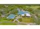 Stunning aerial view of the University Park clubhouse, showcasing its blue tile roof, lush landscaping, and golf course views at 7432 Ascot Ct, University Park, FL 34201
