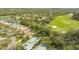 Aerial view of property showcasing the backyard pool, lush landscaping, and proximity to a golf course at 7432 Ascot Ct, University Park, FL 34201