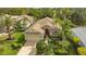 Beautiful single-Gathering home featuring a tile roof and a well-manicured lawn with lush landscaping and mature palm trees at 7432 Ascot Ct, University Park, FL 34201