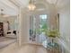 Bright foyer featuring tile floors, arched doorway, glass french doors and a decorative table with a vase of flowers at 7432 Ascot Ct, University Park, FL 34201