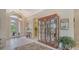 Foyer view with tile floors, glass door entrance, china cabinet, and a glimpse of the kitchen in the background at 7432 Ascot Ct, University Park, FL 34201