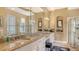 Bright main bathroom featuring double sinks, granite counters, and a large mirror at 7432 Ascot Ct, University Park, FL 34201