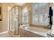 Luxurious bathroom featuring a soaking tub, separate shower, and plantation shutters at 7432 Ascot Ct, University Park, FL 34201