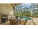 Enjoy outdoor dining on the screened patio with a built-in grill and stunning views of the pool and greenery at 7432 Ascot Ct, University Park, FL 34201