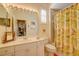 Bright bathroom with single sink vanity, large mirror, shower, and a decorative floral shower curtain at 7762 Us Open Loop, Lakewood Ranch, FL 34202