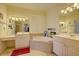 Bright bathroom with dual vanities, a soaking tub, and a large window for natural light at 7762 Us Open Loop, Lakewood Ranch, FL 34202