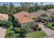 Aerial view of a single-Gathering home with a red tile roof, brick driveway, and lush landscaping at 7762 Us Open Loop, Lakewood Ranch, FL 34202
