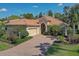 A well maintained single story home with brick driveway, lush landscaping, and a two-car garage at 7762 Us Open Loop, Lakewood Ranch, FL 34202