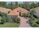 Charming one-story home with a red tile roof, brick paved driveway, and lush tropical landscaping at 7762 Us Open Loop, Lakewood Ranch, FL 34202