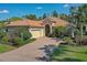 Charming one-story home with a brick driveway, vibrant landscaping, and a two-car garage at 7762 Us Open Loop, Lakewood Ranch, FL 34202