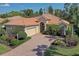 Beautiful home with a tile roof, arched entry, brick driveway, mature landscaping, and a two-car garage at 7762 Us Open Loop, Lakewood Ranch, FL 34202