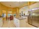 Bright kitchen with a stainless steel refrigerator, kitchen island, and adjacent breakfast nook with windows at 7762 Us Open Loop, Lakewood Ranch, FL 34202