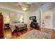 Spacious main bedroom with hardwood floors, ceiling fan, and ensuite bathroom access at 7762 Us Open Loop, Lakewood Ranch, FL 34202