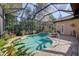 Inviting screened-in in-ground pool with tropical plants, a surrounding patio, and glass enclosure at 7762 Us Open Loop, Lakewood Ranch, FL 34202