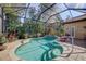 Inviting screened-in in-ground pool with tropical plants and a surrounding brick paver patio at 7762 Us Open Loop, Lakewood Ranch, FL 34202