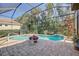 Screened-in pool with brick patio and lush landscaping; perfect for enjoying sunny days at 7762 Us Open Loop, Lakewood Ranch, FL 34202