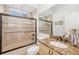Bathroom featuring granite vanity with glass-enclosed shower-tub, tile, and neutral color scheme at 8122 Spring Marsh Dr, University Park, FL 34201