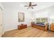 Cozy bedroom featuring hardwood floors, a ceiling fan, and a cushioned daybed with decorative pillows at 8122 Spring Marsh Dr, University Park, FL 34201