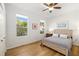 Bright bedroom featuring hardwood floors, two windows with lots of natural light, and a ceiling fan at 8122 Spring Marsh Dr, University Park, FL 34201