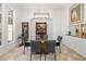 Formal dining room showcasing a glass-top table, modern lighting fixture, and neutral decor for elegant dining at 8122 Spring Marsh Dr, University Park, FL 34201
