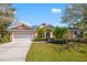 Attractive home with mature landscaping, including manicured lawn and a two-car garage at 8122 Spring Marsh Dr, University Park, FL 34201