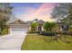 Charming single-story home with a well-manicured lawn, lush greenery, and a two-car garage under a picturesque sky at 8122 Spring Marsh Dr, University Park, FL 34201