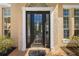 Charming front entry with a black door with sidelights and transom window at 8122 Spring Marsh Dr, University Park, FL 34201