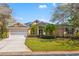 Charming one-story home featuring a lush green lawn and well-manicured landscaping with palm trees at 8122 Spring Marsh Dr, University Park, FL 34201