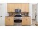 Kitchen showcasing wood cabinets, granite counters and backsplash, and stainless steel appliances at 8122 Spring Marsh Dr, University Park, FL 34201