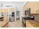 Kitchen featuring stainless steel appliances, wooden cabinets, granite countertops, and tile flooring at 8122 Spring Marsh Dr, University Park, FL 34201