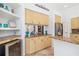 Kitchen area featuring wood cabinets, granite counters, wine cooler, open shelving, and stainless refrigerator at 8122 Spring Marsh Dr, University Park, FL 34201