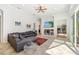 Bright living room featuring tile floors, gray sofa, and an entertainment center with a large television at 8122 Spring Marsh Dr, University Park, FL 34201