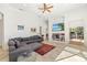 Open-concept living room with gray sectional, tile flooring, and view of built-in shelving at 8122 Spring Marsh Dr, University Park, FL 34201