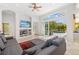Bright living room featuring a comfortable gray sectional, ceiling fan, and sliding glass doors to the pool at 8122 Spring Marsh Dr, University Park, FL 34201