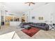 Spacious living room with tile floors and a gray sectional sofa open to the kitchen at 8122 Spring Marsh Dr, University Park, FL 34201
