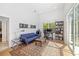 Well-lit office space featuring a modern blue sofa, desk, bookshelf, and a stylish patterned rug at 8122 Spring Marsh Dr, University Park, FL 34201