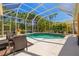 Enclosed pool area features a seating area and lush tropical landscaping for a private oasis at 8122 Spring Marsh Dr, University Park, FL 34201