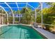 View of the pool, enclosed by a screen and featuring tropical landscaping creating a private retreat at 8122 Spring Marsh Dr, University Park, FL 34201