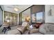 Cozy enclosed balcony boasts seating, small dining table, tile floors, and access to interior spaces at 8735 Midnight Pass Rd # 105B, Sarasota, FL 34242